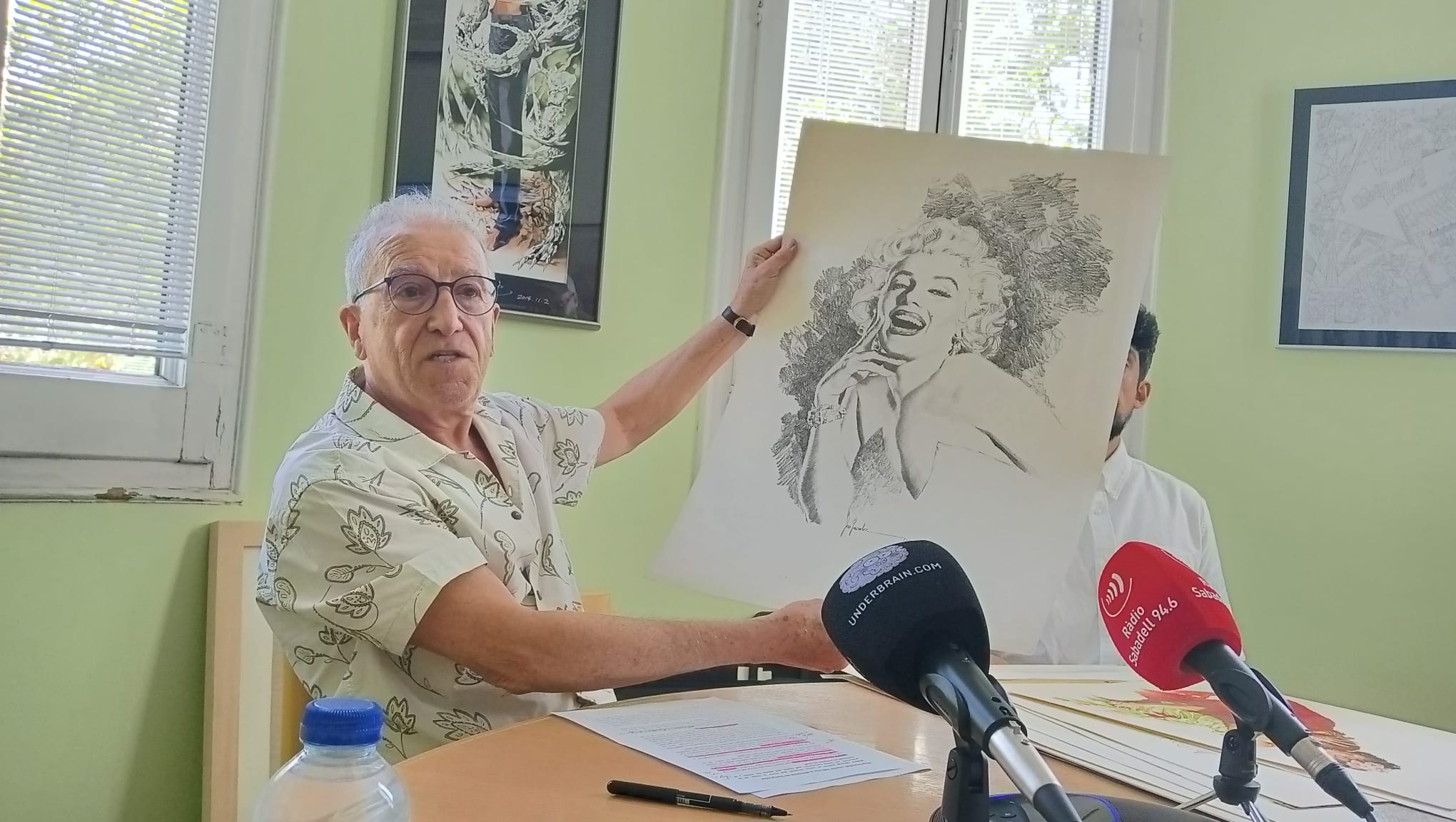 Rafael Martínez mostrant un retrat de Marilyn Monroe de l'autor Pepe González