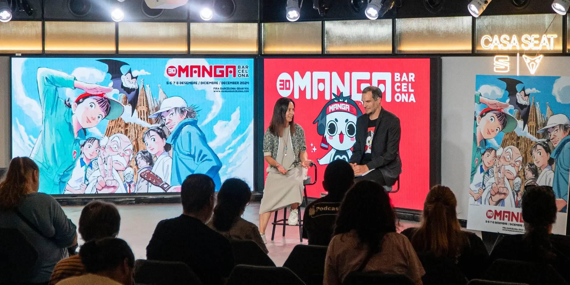 Maritxell Puig i Oriol Estrada durant la presentació del cartell de Naoki Urasawa pel 30è Manga Barcelona. Ficomic